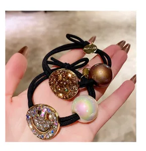 Close-up detail of Korean style rhinestone metal smiley face hair tie set, elegant accessory.