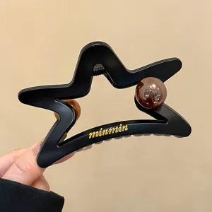 Grande molletta per capelli a stella traforata con finitura opaca e perle marroni.