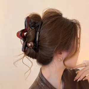 Grande molletta per capelli a stella cava con perla in tartaruga scura, ideale per capelli spessi.