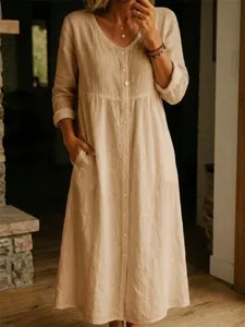 Detailed view of a casual long sleeve button down linen dress in a cozy indoor scene.