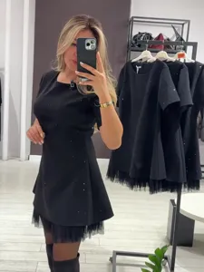 Detailansicht des schwarzen kurzen Ärmel Strass Schlankheitskleides mit Mesh-Saum im Showroom.