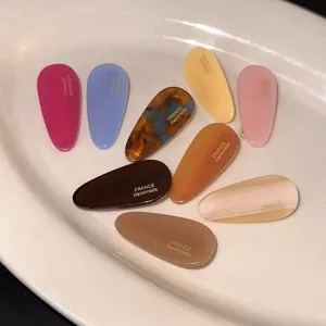 Detailansicht bunter Acetat-Ovale Haarspangen mit feiner Beschriftung und Entenschnabel.