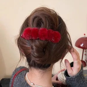 Detailed view of the vintage red plush hair claw clip shown on hair styling texture.