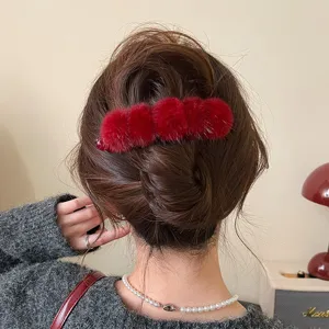 Detailed view of red plush hair claw clip worn on hair, soft texture and vintage style.