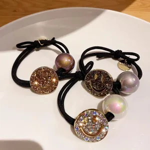 Rhinestone smiley face hair tie with iridescent pearl charm, elegant black elastic ponytail holder.
