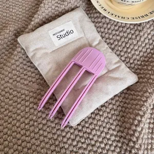 Hair root volume clip detail view, purple plastic hair styling tool for fluffy hair.