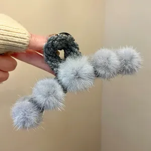 Plush hair claw clip with fluffy grey faux fur pom poms, elegant autumn winter hair accessory for women.
