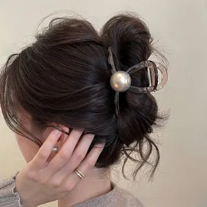 Dettaglio molletta per capelli con perla grigia, elegante pinza trasparente per acconciature chic.