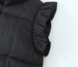 Black winter puffer vest detail showing stylish ruffled cap sleeves and warm quilted fabric.