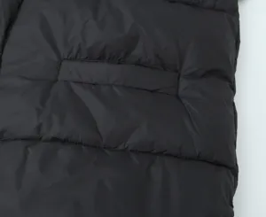 Black padded vest pocket detail, quilted winter gilet close-up view, casual outerwear.