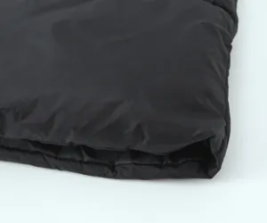 Detail view of the black quilted cotton vest fabric, showing the soft and warm texture clearly.