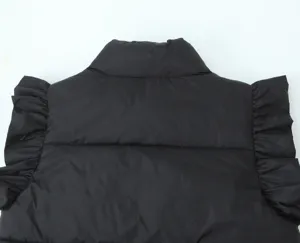Detail shot of women's black padded vest featuring stylish ruffle shoulders and stand collar design.
