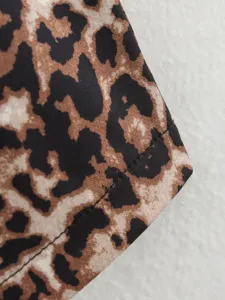 Gros plan détaillé du tissu imprimé léopard stylé, montrant texture et belles coutures.