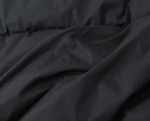 Black cotton vest fabric detail close-up showcasing soft texture and natural fabric folds.