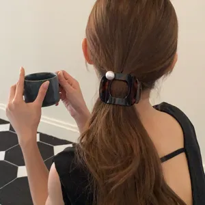 Detailansicht der eleganten Retro-Hornschnitt-Perlen-Haarspange im getragenen Zustand.