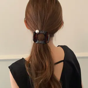 Detailansicht einer vintage Schildpatt Haarspange mit Perle, elegantes Haarschmuck.