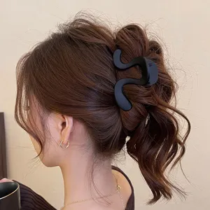 Vista dettagliata di un'elegante molletta per capelli nera astratta per acconciature raccolte.