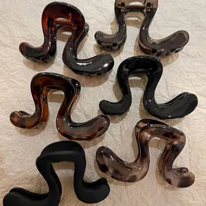 Vista dettagliata di eleganti pinze per capelli irregolari, pratiche mollette in resina per acconciature.