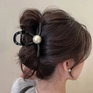 Elegante molletta per capelli nera con grande perla grigia per acconciature da donna.