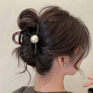 Primo piano dettagliato di un elegante mollettone per capelli con perla grigia e raffinata.