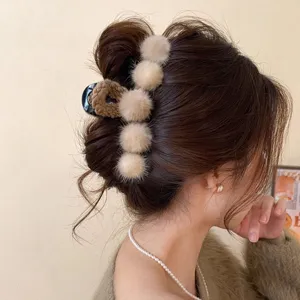 Detailed view of fluffy plush hair claw clip for women, soft winter hair styling accessory.