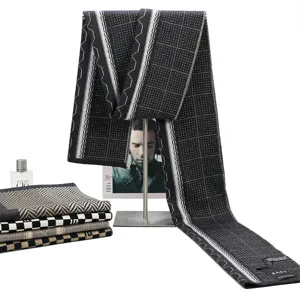 Detailed view of winter thick knit wool scarf with classic black and white plaid pattern.