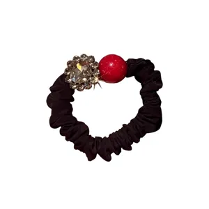 Black hair scrunchie with sparkling rhinestones and a bright red bead for women and girls daily.