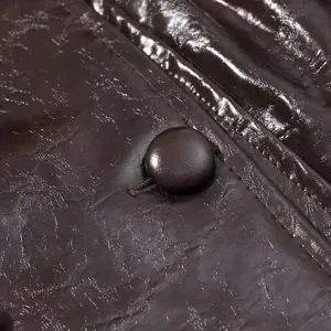 Primer plano detallado del botón de la chaqueta de cuero marrón brillante mujer