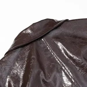 Primer plano de la espalda y el cuello de una chaqueta de cuero brillante marron con detalles.