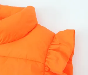 Close-up detail of orange puffer vest collar and ruffled sleeve, casual winter fashion style.
