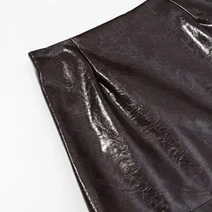 Detalle de piel sintética brillante, primer plano textura marrón oscuro para ropa de invierno.