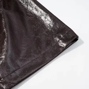 Detalle de cuero sintético brillante, marrón oscuro rico, textura de ropa elegante.