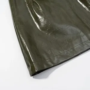 Primer plano detallado del dobladillo de cuero sintético brillante verde oscuro.