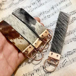 Cowhide leather keychain detail view, featuring genuine calf hair texture and rose gold hardware.