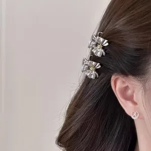 Primo piano di un fermaglio per capelli a fiocco in metallo argentato molto elegante.