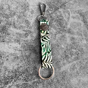 Detailed view of western genuine leather embossed keychain with metal hardware and vintage concho.