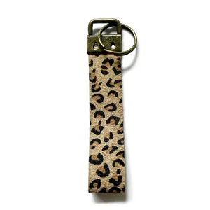 Detailansicht des Leopardenmuster Leder Schlüsselanhänger mit antiker Bronzefarbe Metallbeschlag.