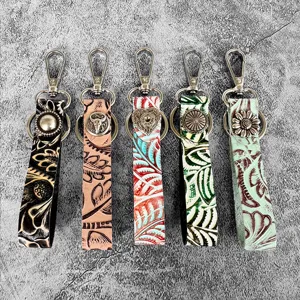 Detailed view of western style genuine leather embossed keychains in multi colors, vintage bag charms.