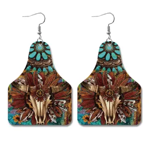 Detailopname van westerse vintage lederen oorbellen met unieke schedel en turquoise print.