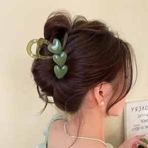 Detailansicht einer grünen Jelly Herz Haarklammer in einer Hochsteckfrisur, elegantes Haarteil.