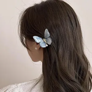 Chic blue butterfly hair clip detail, elegant side hairpin with pearl pendant for women fashion.