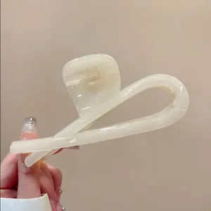 Detailaufnahme der minimalistischen Acryl Haarklammer, elegantes cremeweißes Design.