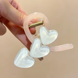 Nahaufnahme der rosa Jelly Haarklammer mit süßen weißen Herzen und stabiler Metallfeder für Styling.