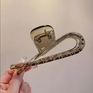 Nahaufnahme der transparenten grauen Acryl Haarklammer mit feiner eleganter Struktur.