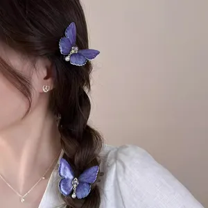 Detail view of purple butterfly hair clip with pearls and rhinestones on braided hair style.