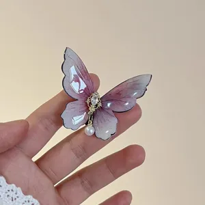 Close-up detail of the elegant gradient butterfly hair clip with dazzling rhinestones and pearl.