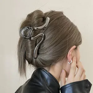 Minimalist metal hair claw detail shot, sleek irregular line design for elegant hair styling accessory