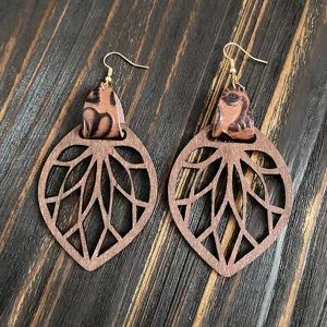Detail en gros plan de boucles d'oreilles en bois creux vintage avec accent cuir dore.