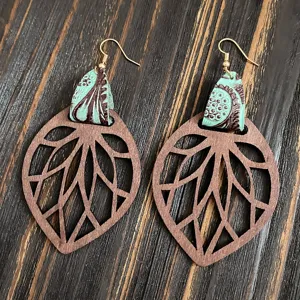 Vue détaillée de boucles d'oreilles pendantes en bois rétro avec des détails en cuir gaufré.