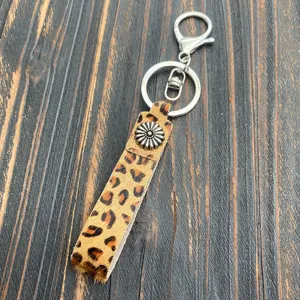 Leopard print cowhide leather keychain detail shot, vintage metal flower charm and ring.